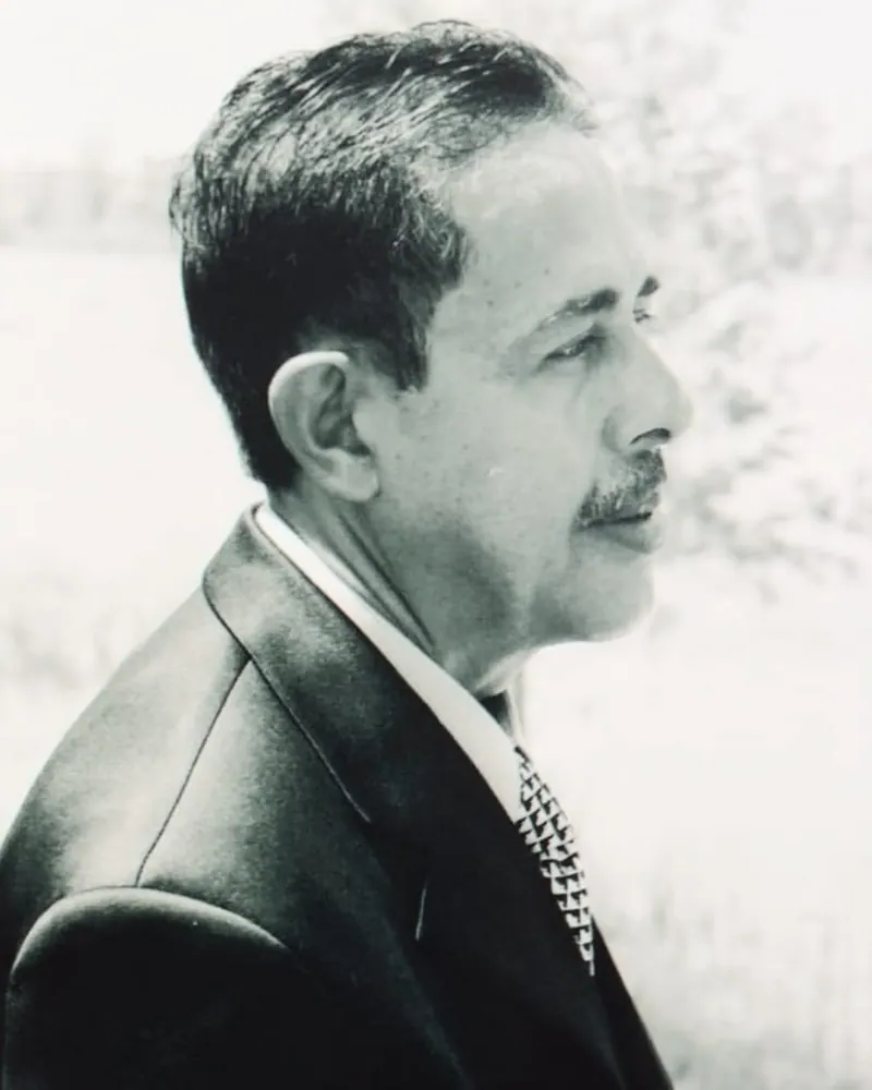 Retrato em preto e branco do Dr. Eliezer Guilherme, de perfil, de terno e gravata